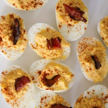 million dollar deviled eggs with bacon on top.