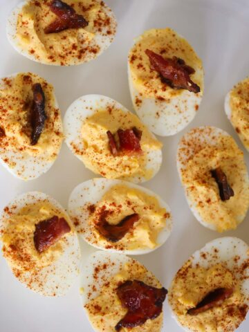 million dollar deviled eggs with bacon on top.
