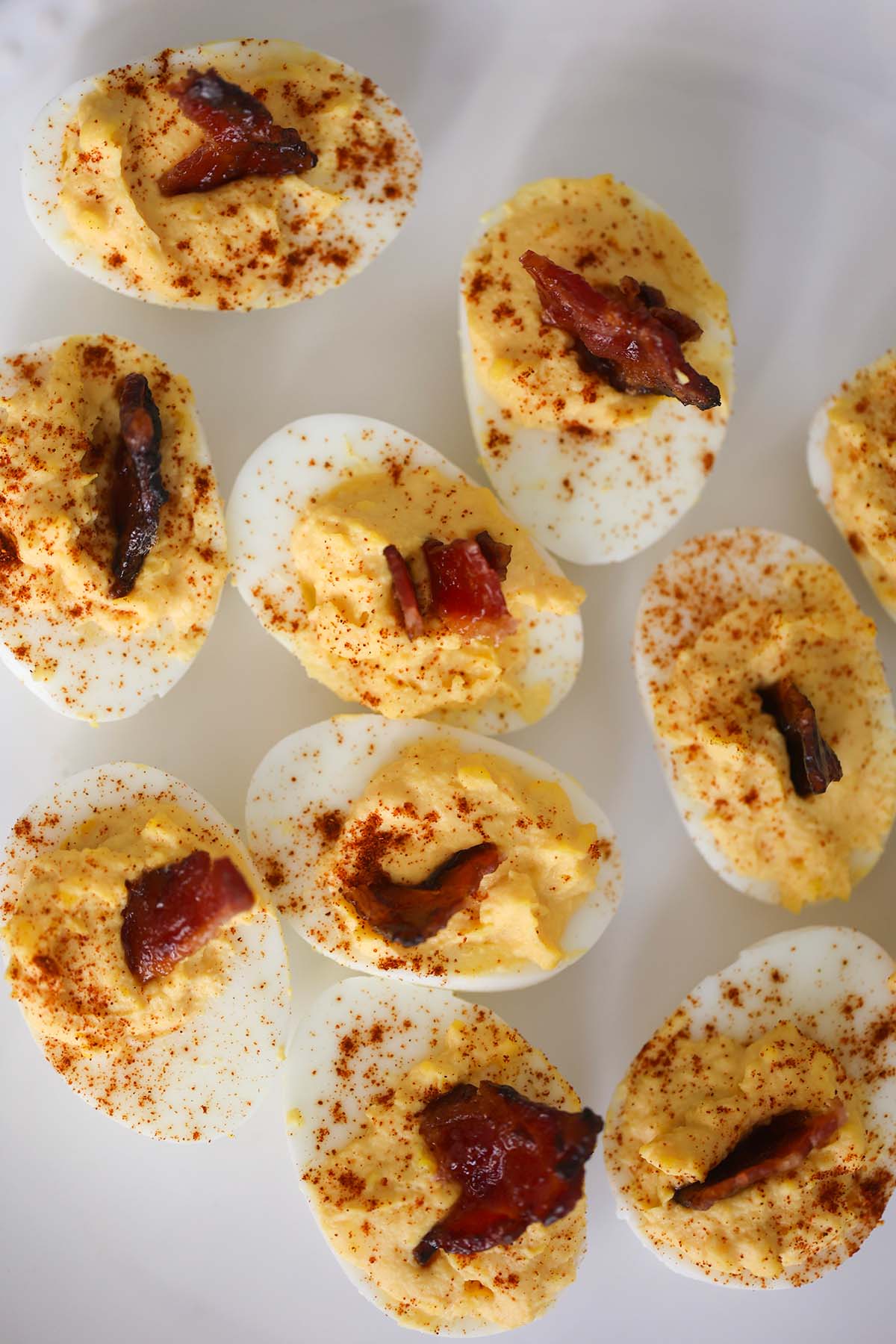 million dollar deviled eggs with bacon on top. 
