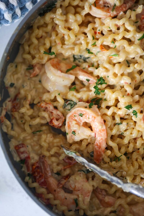 Tuscan shrimp pasta in a skillet up close.