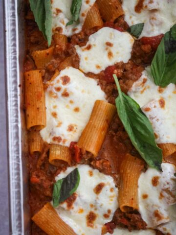 Baked rigatoni with fresh basil on top.