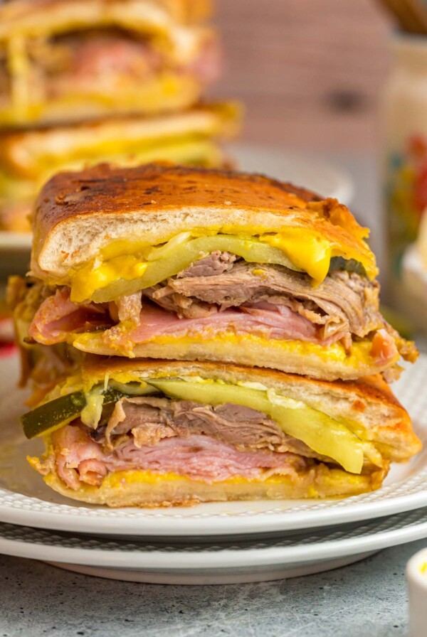 Cuban sandwich sliced in half on a white plate.