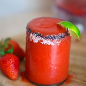 frozen strawberry margarita in a glass with salt on the rim.