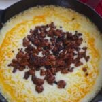 queso fundido in a cast iron skillet.