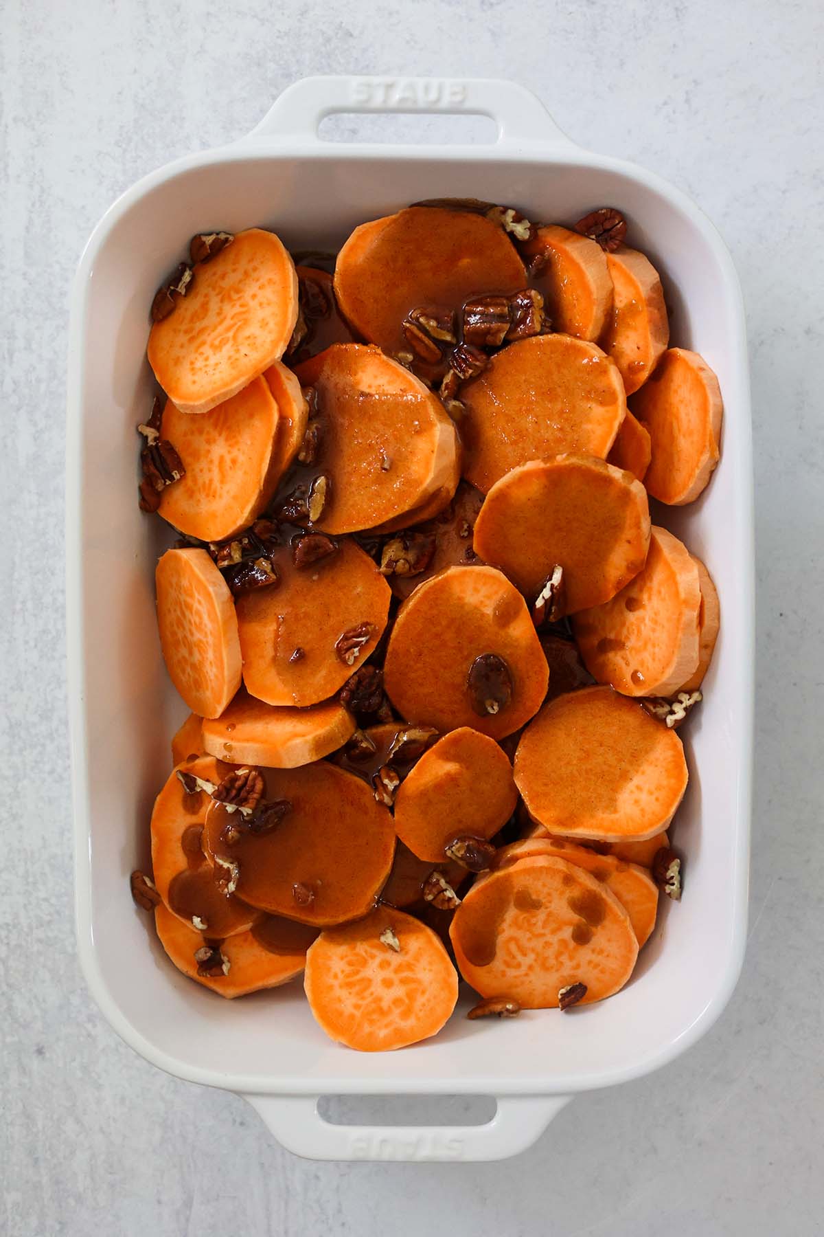sliced yams with sauce and pecans on top.