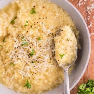 A bowl of pastina with parmesan cheese and parsley on top.