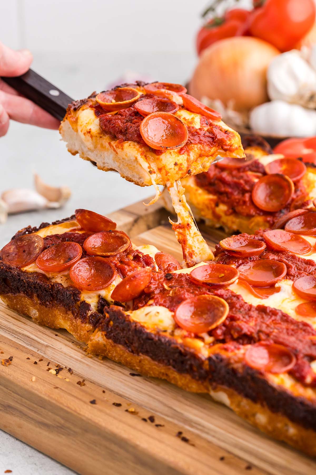 Detroit style pan pizza on a cutting board.