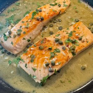 Salmon piccata in a cast iron skillet.