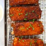 Four honey chipotle fried mozzarella sticks on a rack.
