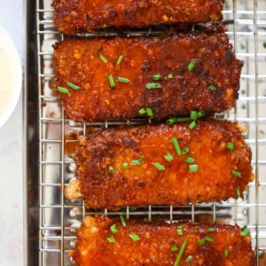 Four honey chipotle fried mozzarella sticks on a rack.