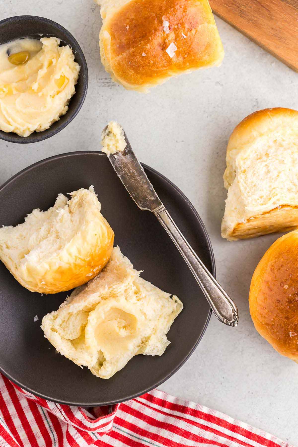 A roll with honey butter and a knife on the side.