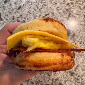 A hand holding a McGriddle sandwich.
