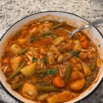 Maryland crab soup in a bowl with a spoon.