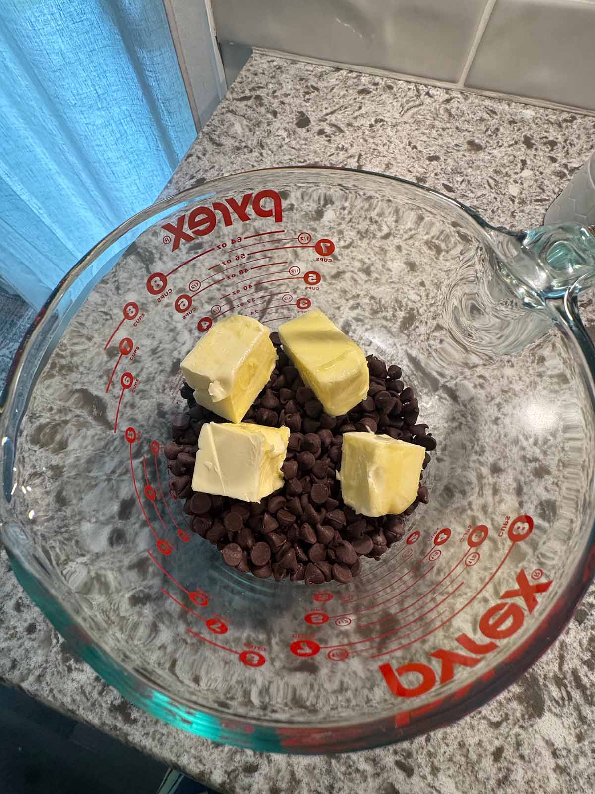 Butter and chocolate chips in a measuring cup. 