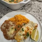 Green Chile chicken enchiladas with yellow rice and refried beans.