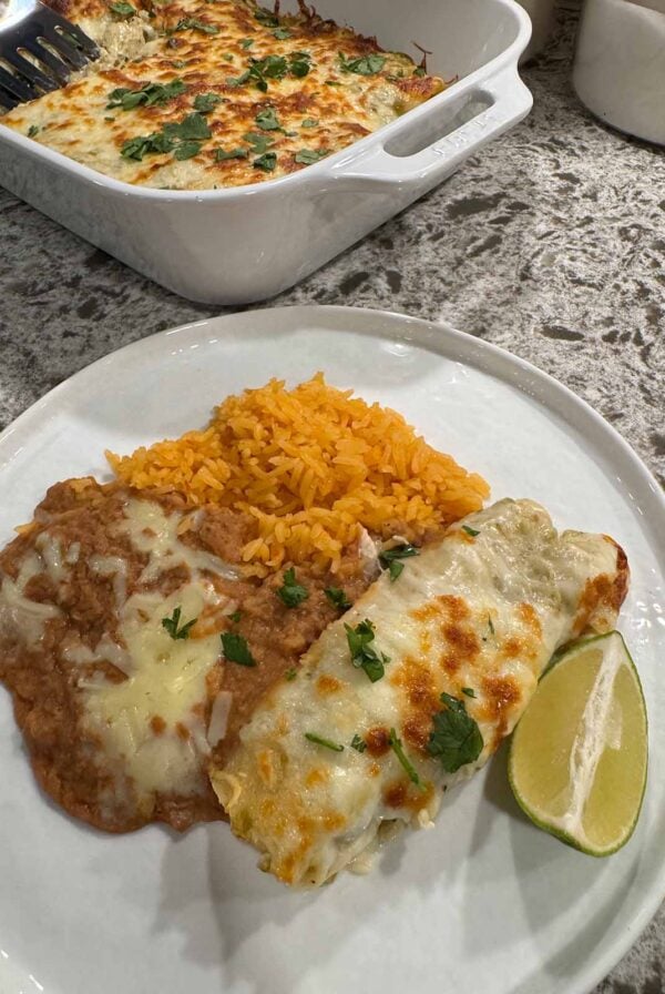 Green Chile chicken enchiladas with yellow rice and refried beans.