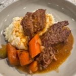 pot roast with mashed potatoes, gravy, and veggies.