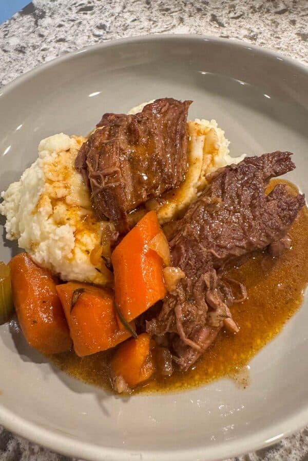 pot roast with mashed potatoes, gravy, and veggies.