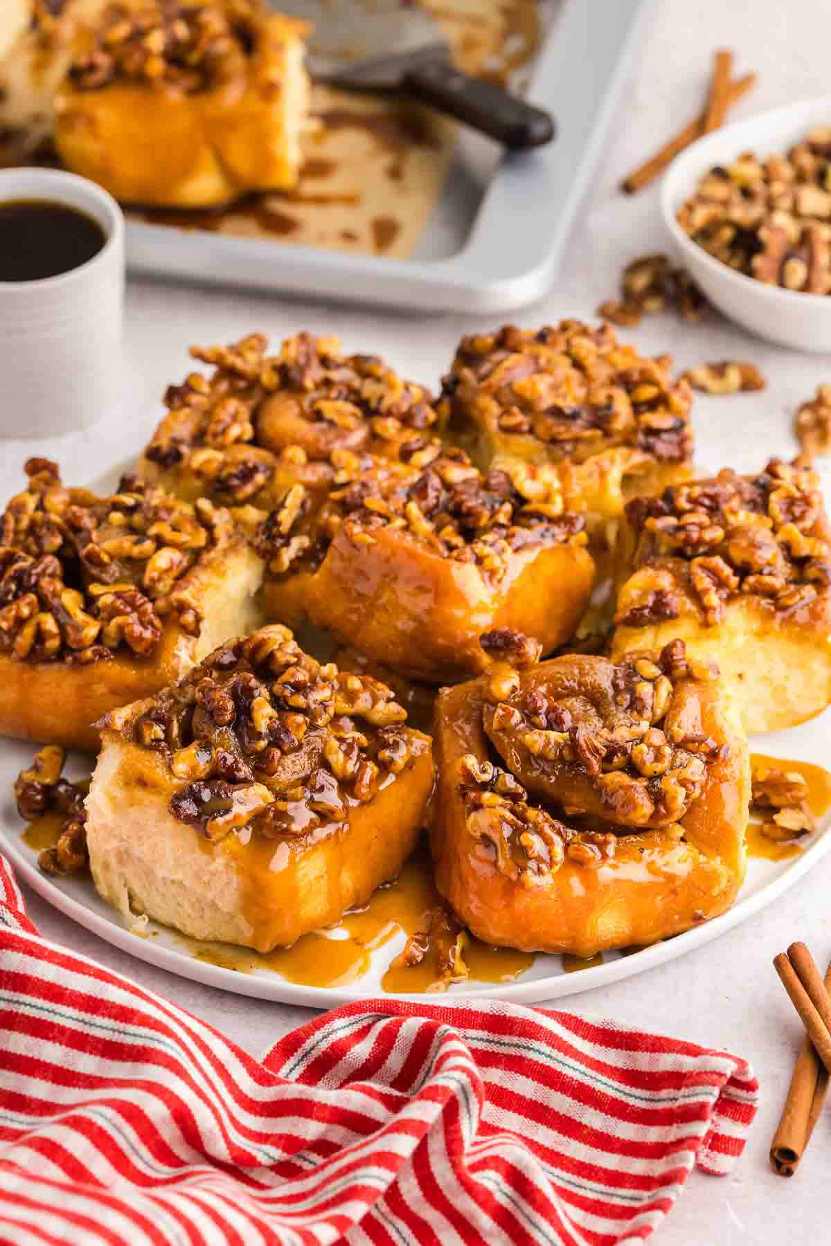 sticky buns on a white plate with a cup of coffee on the side.