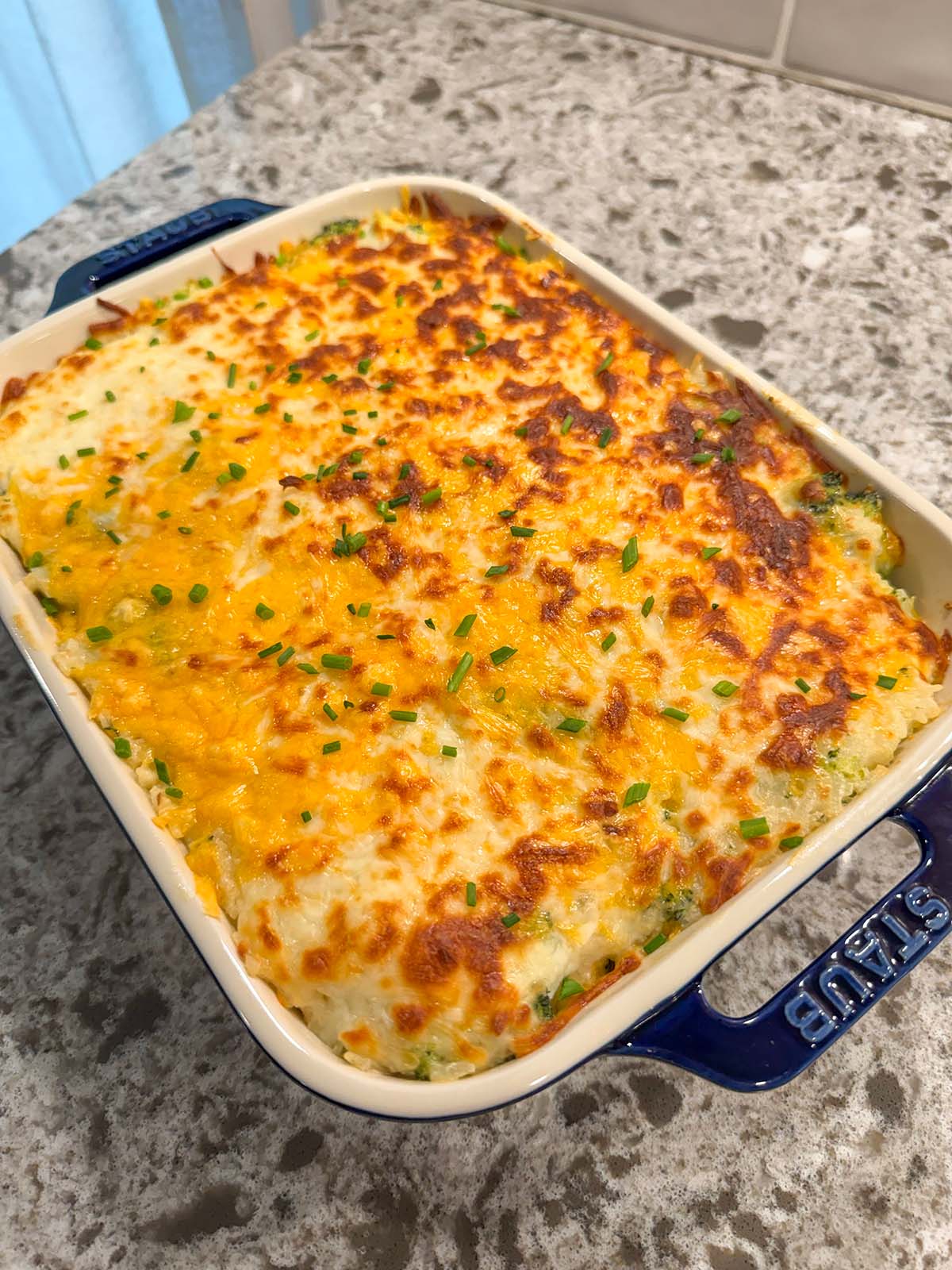 broccoli rice casserole in a 9x9 blue baking dish.