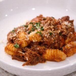 Braised beef with gnocchi in tomato sauce, topped with parmesan and parsley.
