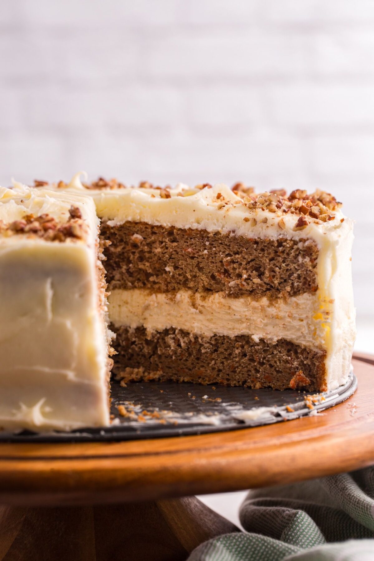 Whole carrot cake cheesecake with one slice removed.