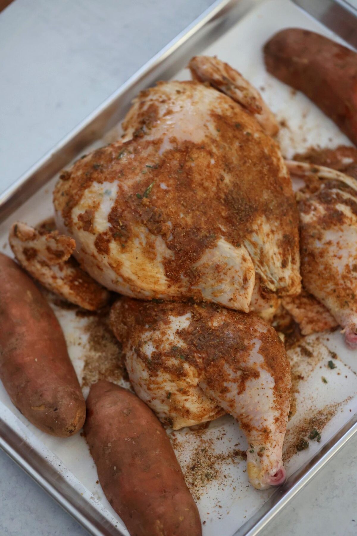 raw seasoned chicken and uncooked sweet potatoes.