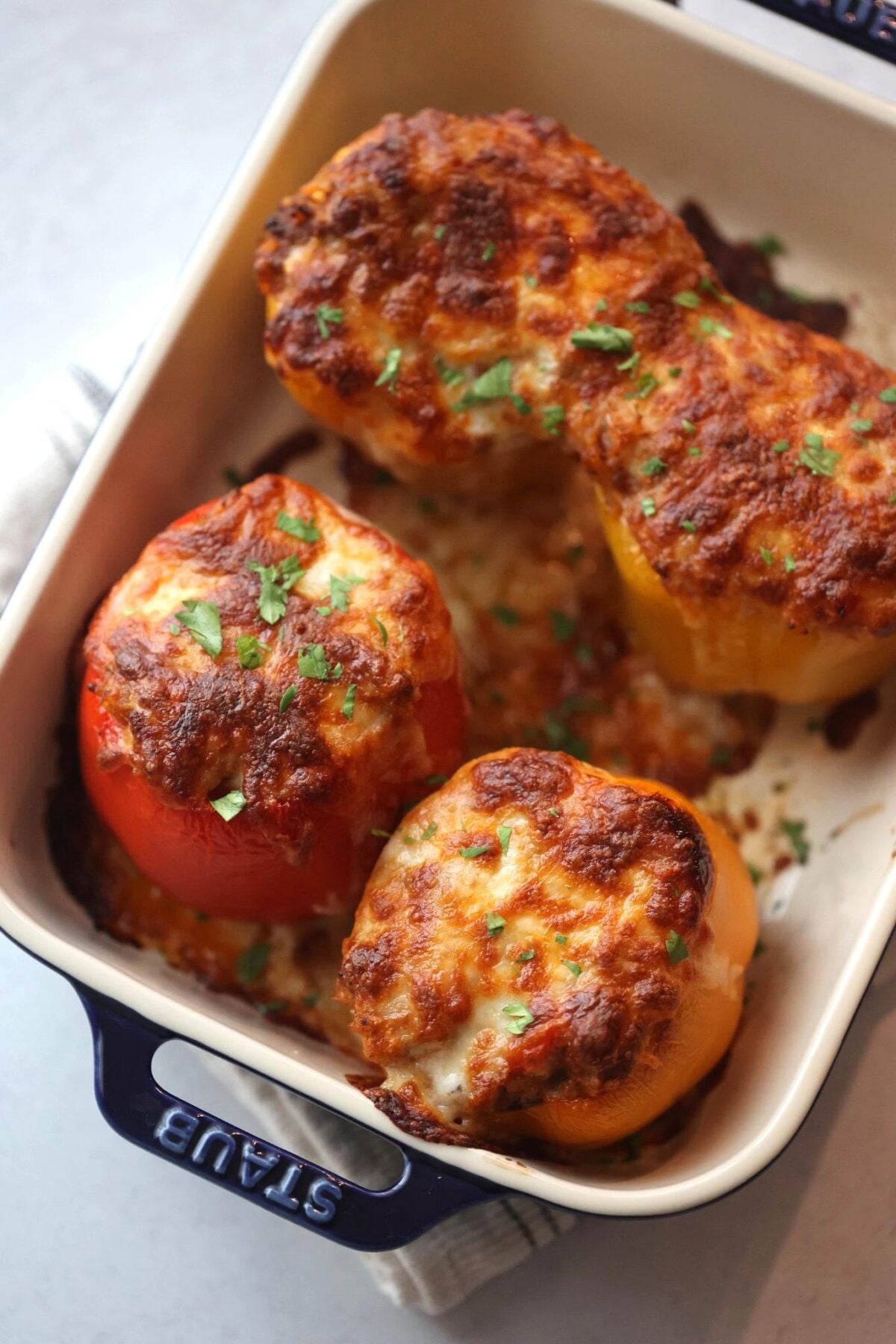 Four cheesy stuffed bell peppers filled with beef, cheese, and rice.