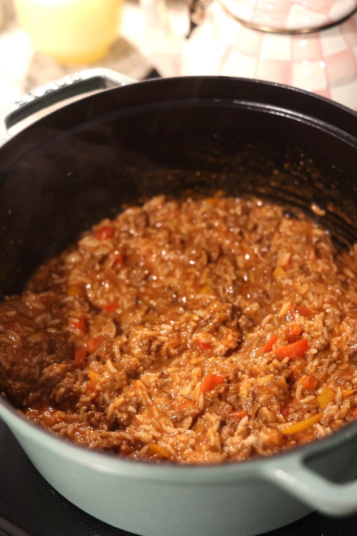 Ground beef and rice cooking in a black dutch oven.