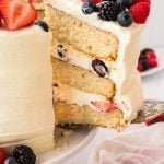 A slice being pulled from a whole Chantilly cake.