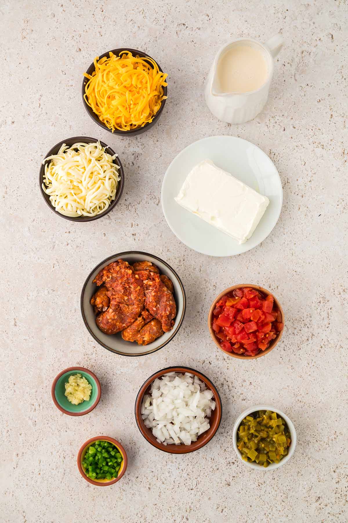 shredded cheese, cream cheese, raw chorizo, diced tomatoes, onions, garlic, peppers, and evaporated milk.