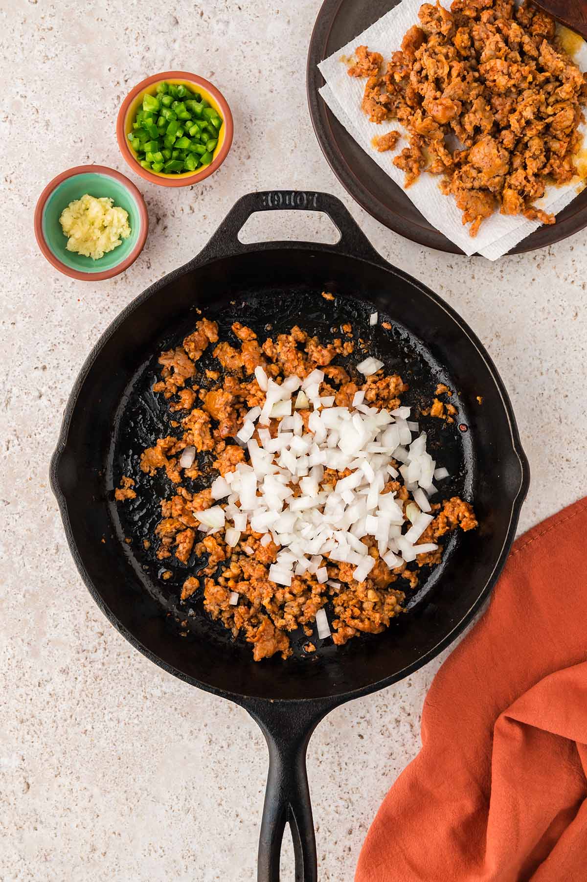 chorizo and onions in a black iron skillet.