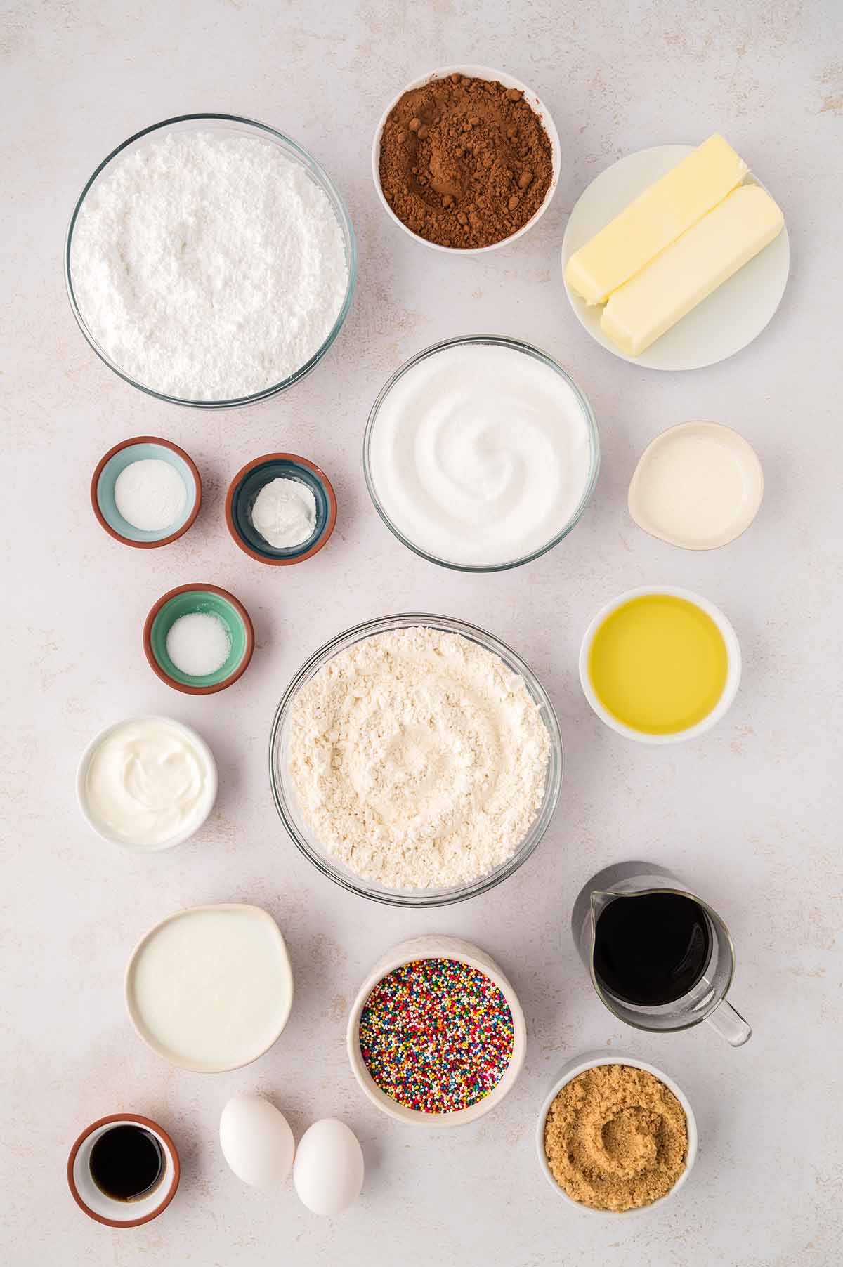Ingredients for chocolate cake and vanilla buttercream with sprinkles.