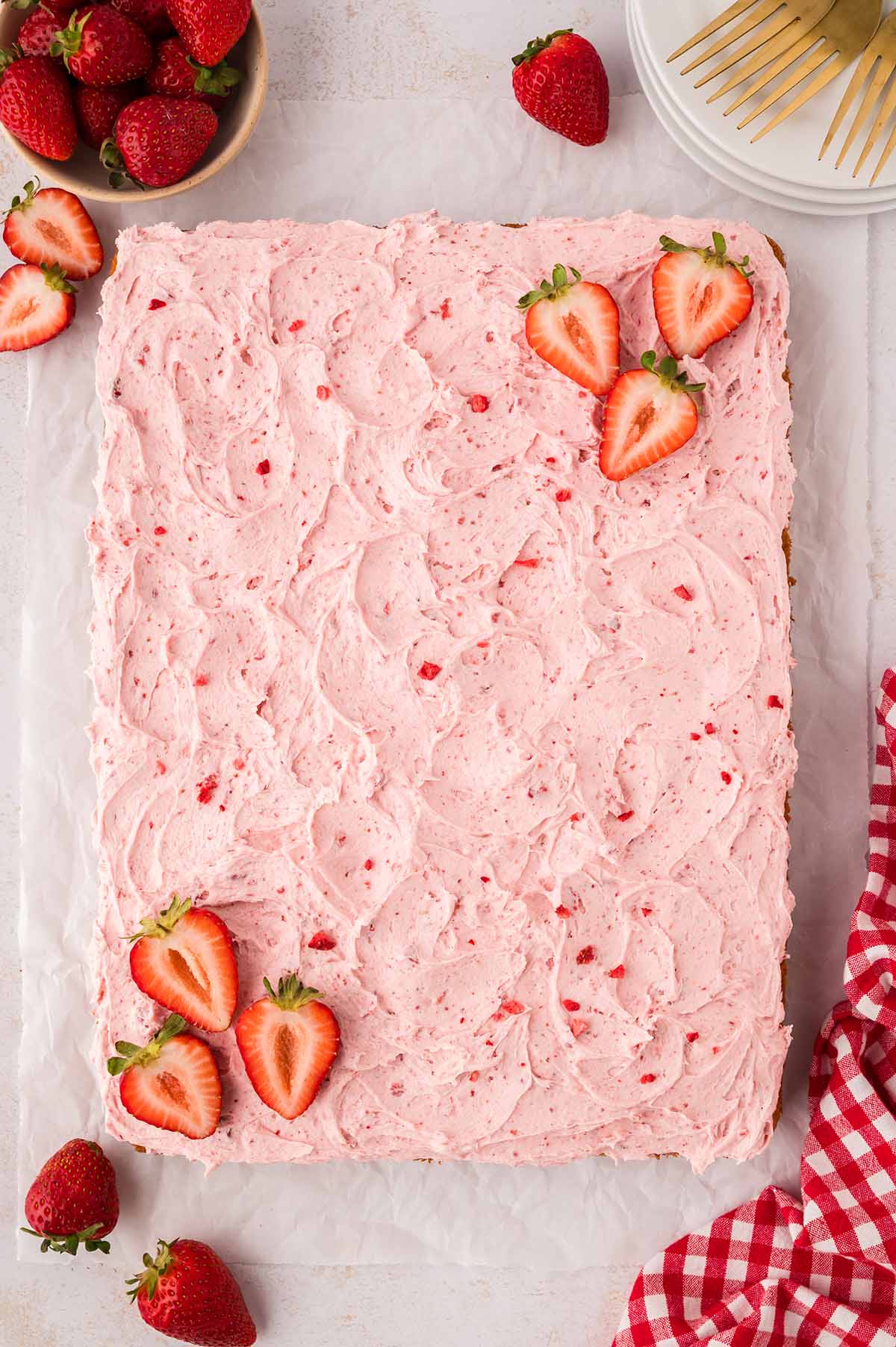 9x13 strawberry cake decorated with buttercream and fresh strawberries.