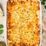 Baked white chicken lasagna with fresh parsley on top.