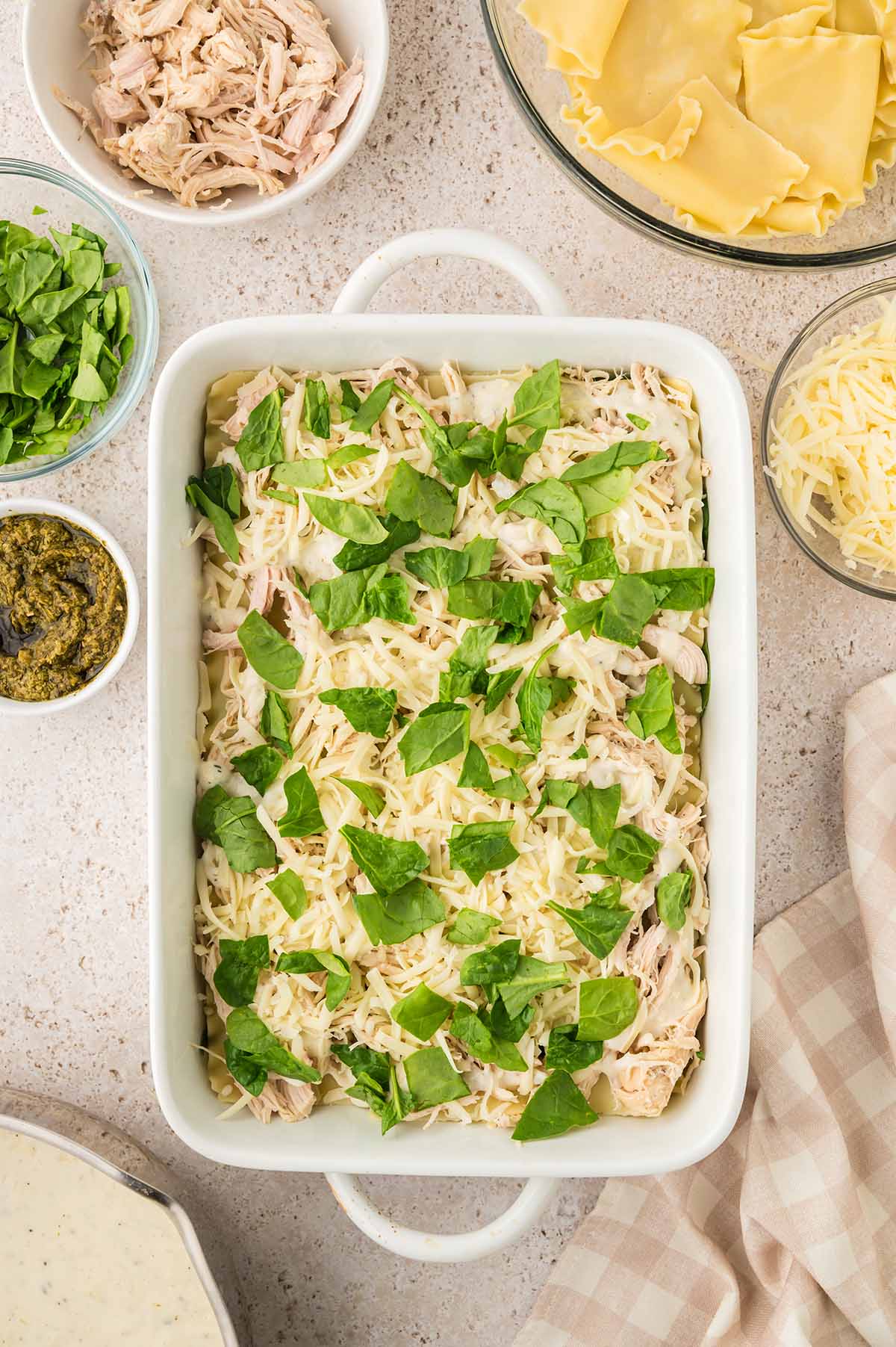Fresh spinach and shredded mozzarella cheese on top of lasagna noodles.