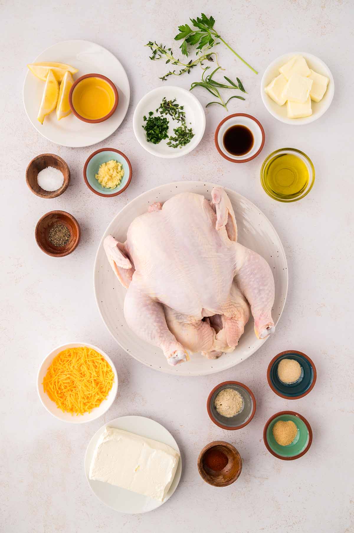 raw whole chicken, lemon, butter, herbs, spices, garlic, oil, and cheese.