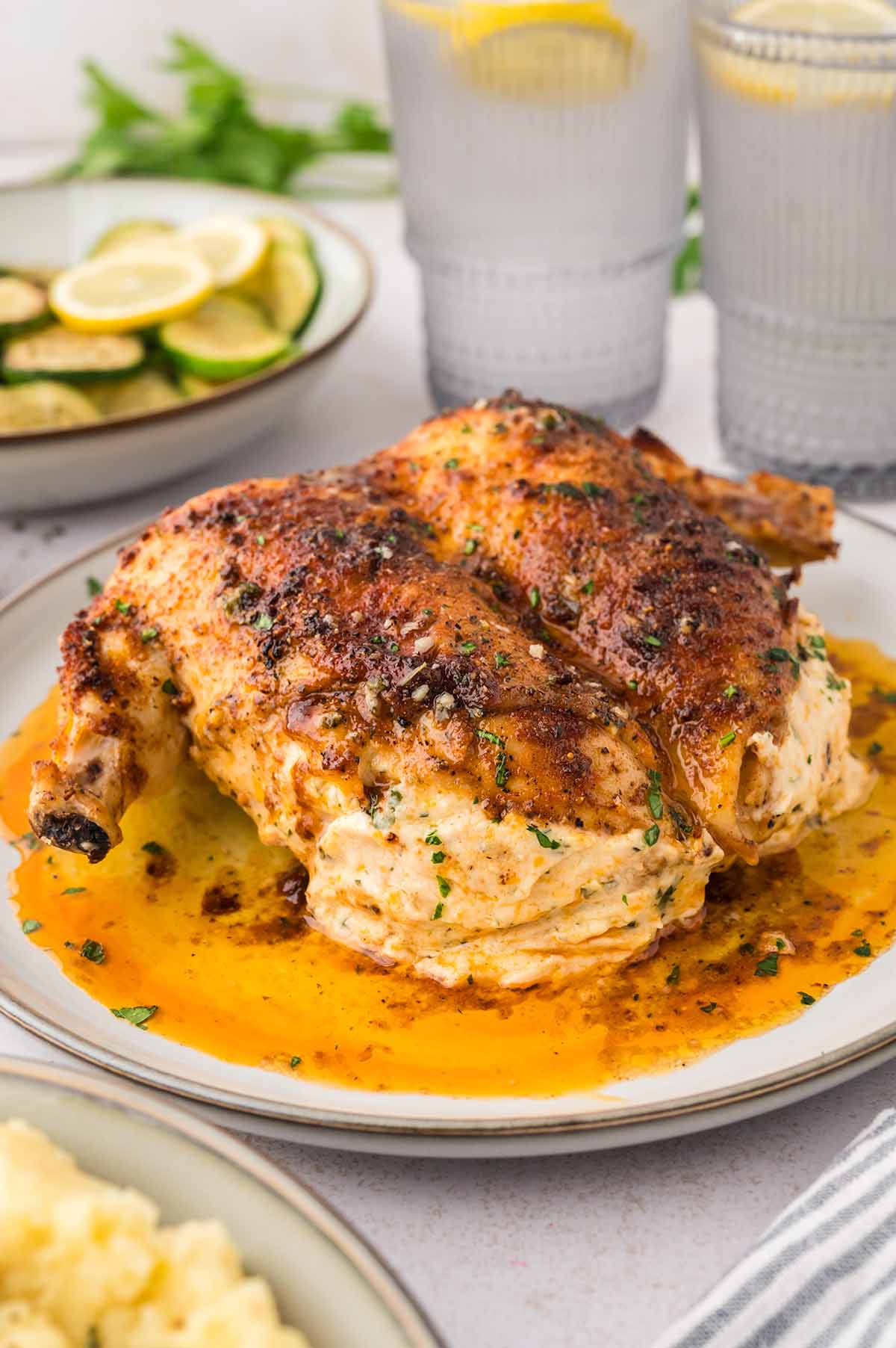 Stuffed chicken on a white plate.