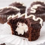A chocolate cupcake filled with marshmallow cream sliced in half.