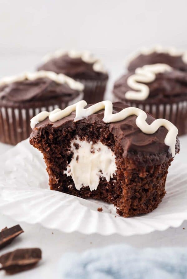 A chocolate cupcake filled with marshmallow cream sliced in half.