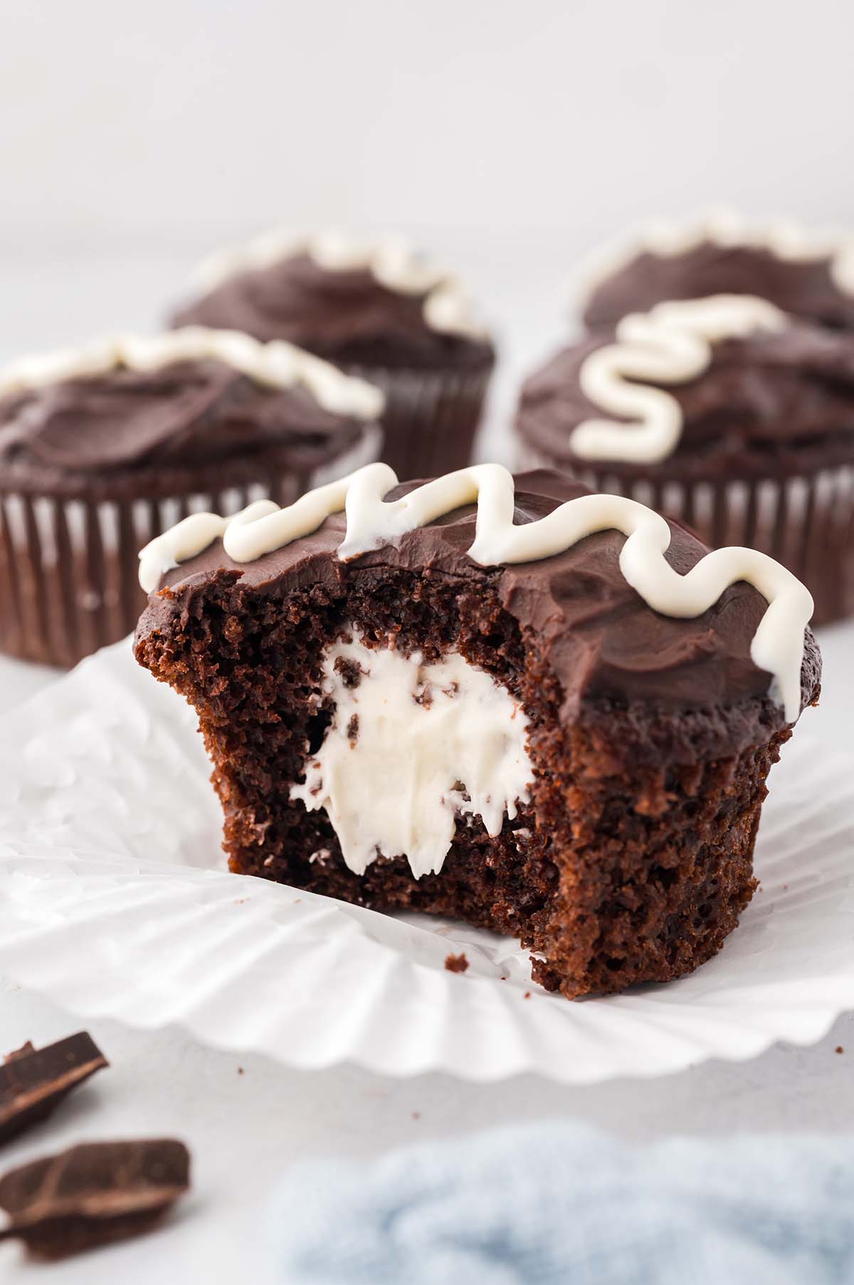 A chocolate cupcake filled with marshmallow cream sliced in half.