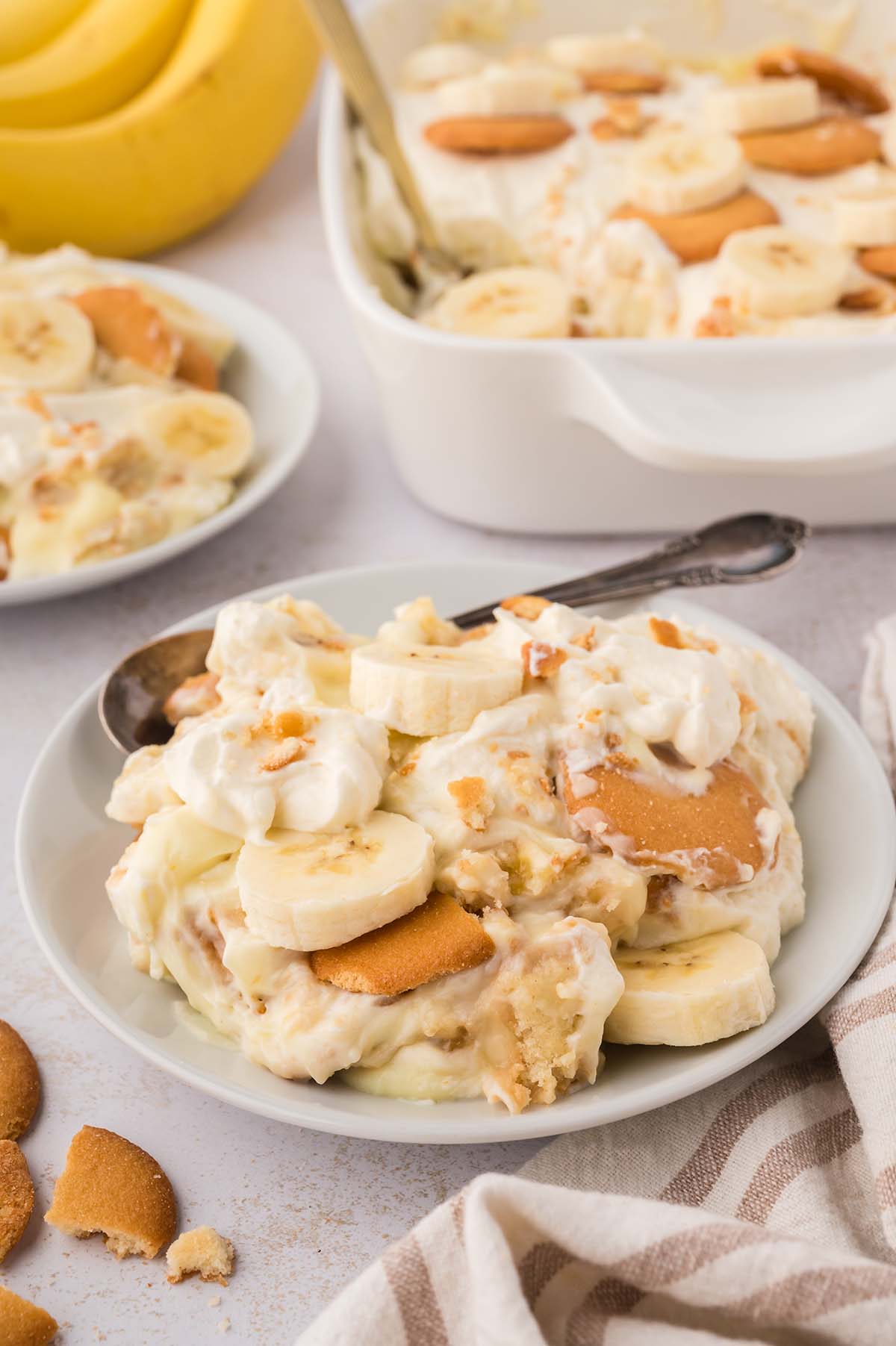 banana pudding on a white plate with a spoon on the side.