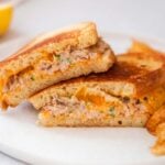 Spicy tuna melt sandwiches on a white plate.