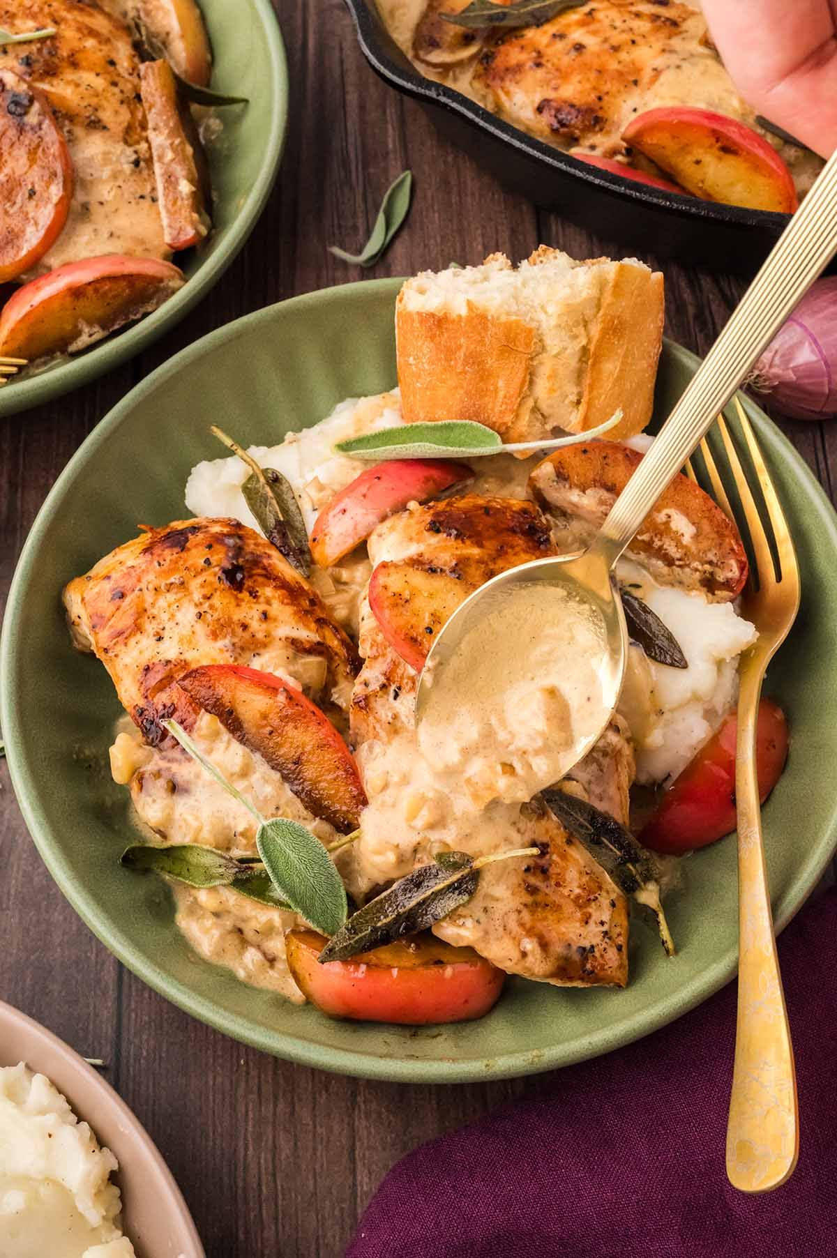 spoon pouring cream sauce over chicken.