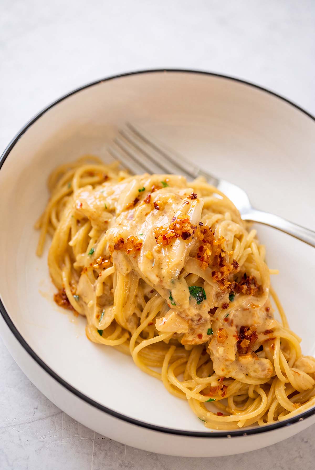 onion pasta in a bowl with a fork on the side.