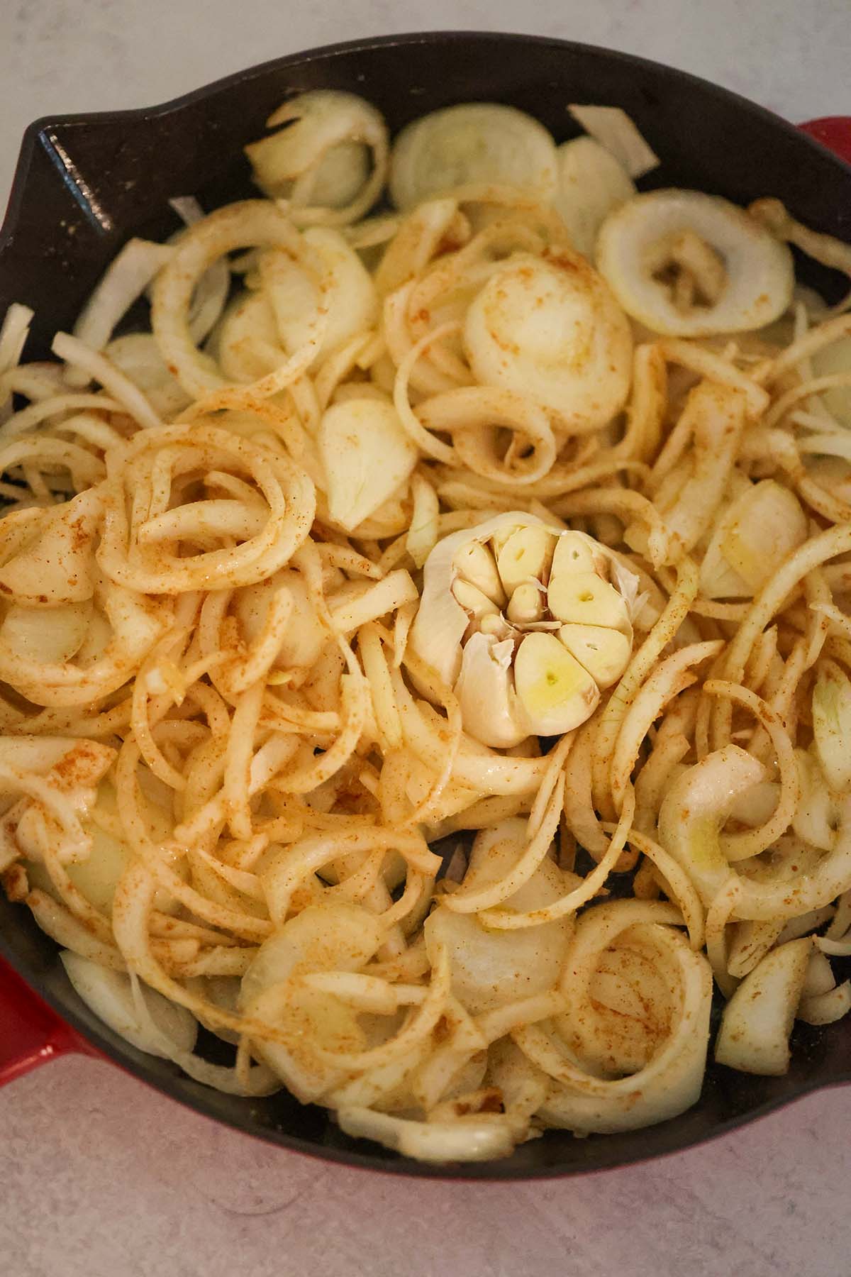 onions and a head of garlic in a skillet.