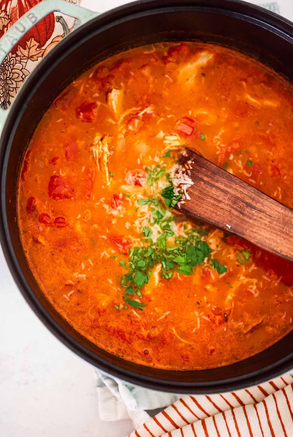 a pot filled with soup and a wooden spoon.