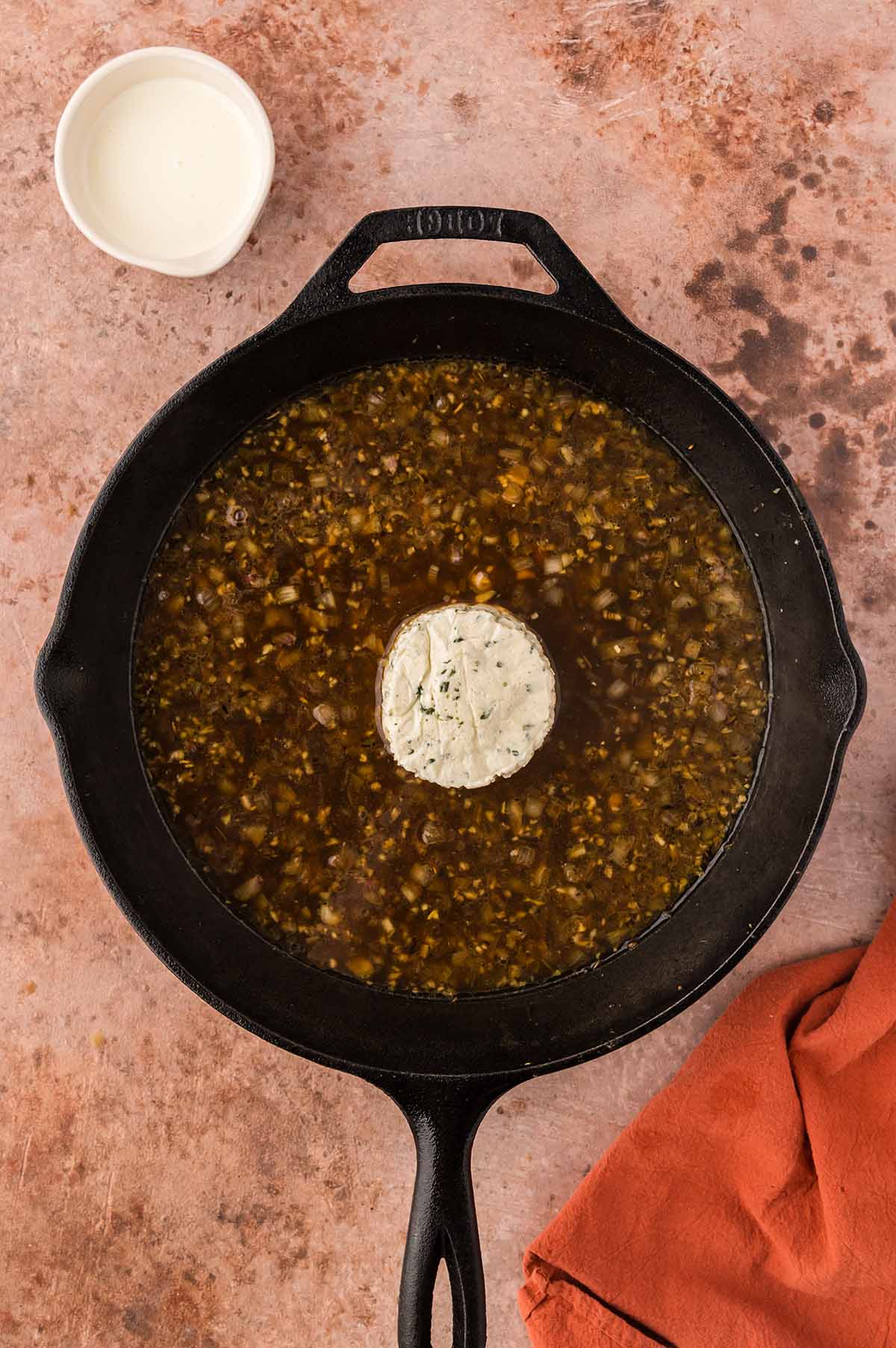 chicken stock and Boursin cheese in a skillet.