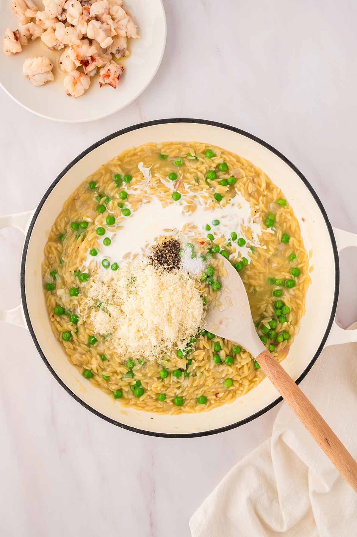 creamy orzo with parmesan and spices on top with cooked lobster meat on the side.