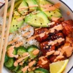salmon avocado rice bowl with chop sticks.